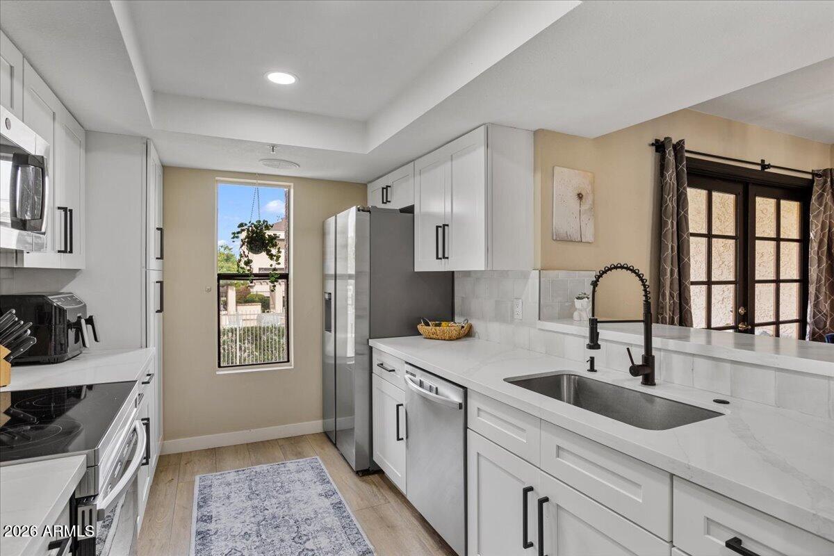 7510 East Thomas Road, Unit 216 Scottsdale, AZ 85251 - Photo 16 of 19 a kitchen with a sink cabinets and window