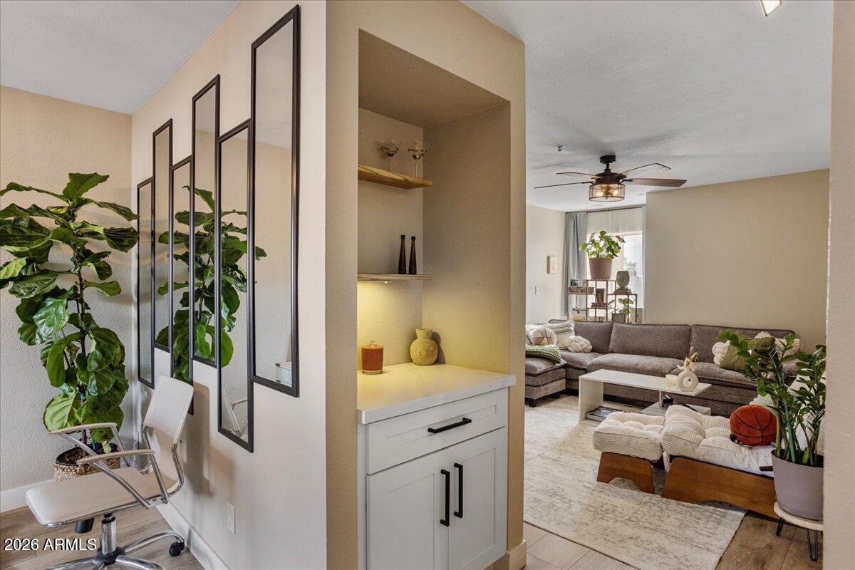 7510 East Thomas Road, Unit 216 Scottsdale, AZ 85251 - Photo 3 of 19 a hallway with a couch and chandelier