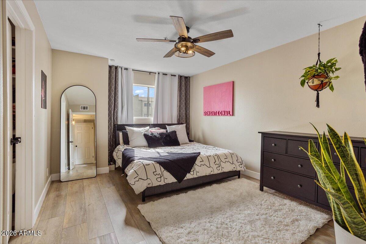 7510 East Thomas Road, Unit 216 Scottsdale, AZ 85251 - Photo 7 of 19 a bed room with a bed and a chandelier