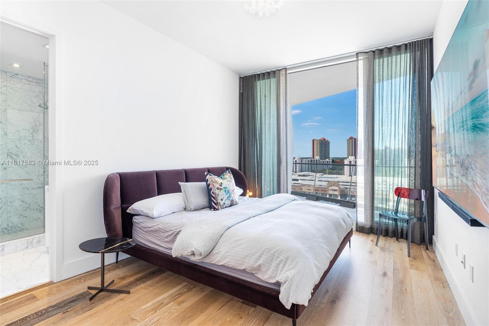 16901 Collins Avenue, Unit 902 Sunny Isles Beach, FL 33160 - Photo 21 of 52 a bedroom with a bed and a large mirror next to a large window