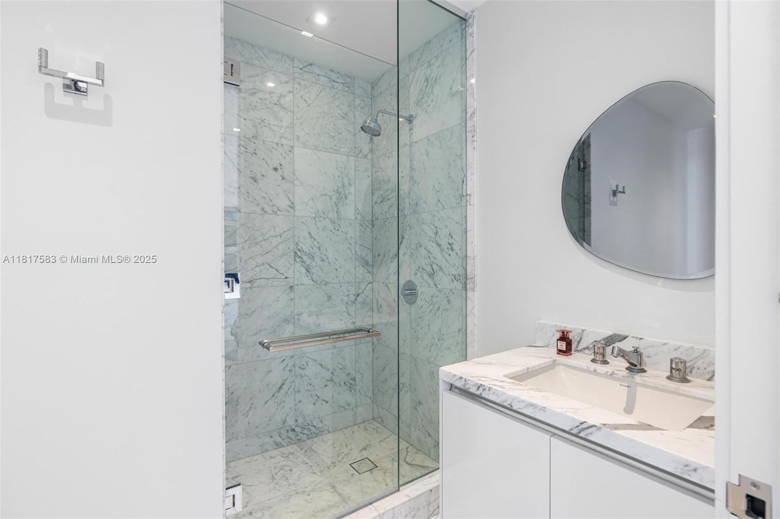 16901 Collins Avenue, Unit 902 Sunny Isles Beach, FL 33160 - Photo 22 of 52 a bathroom with a granite countertop sink a mirror and shower