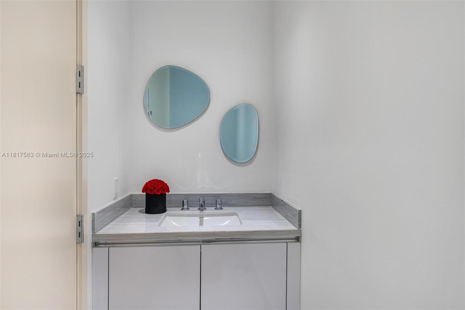 16901 Collins Avenue, Unit 902 Sunny Isles Beach, FL 33160 - Photo 29 of 52 a bathroom with a sink and a mirror