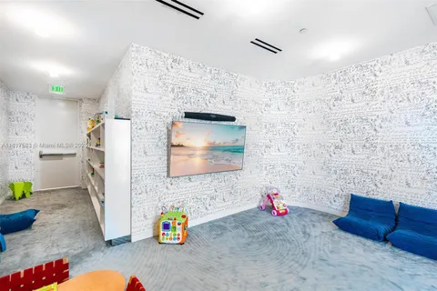 a room with lots of white furniture and rug