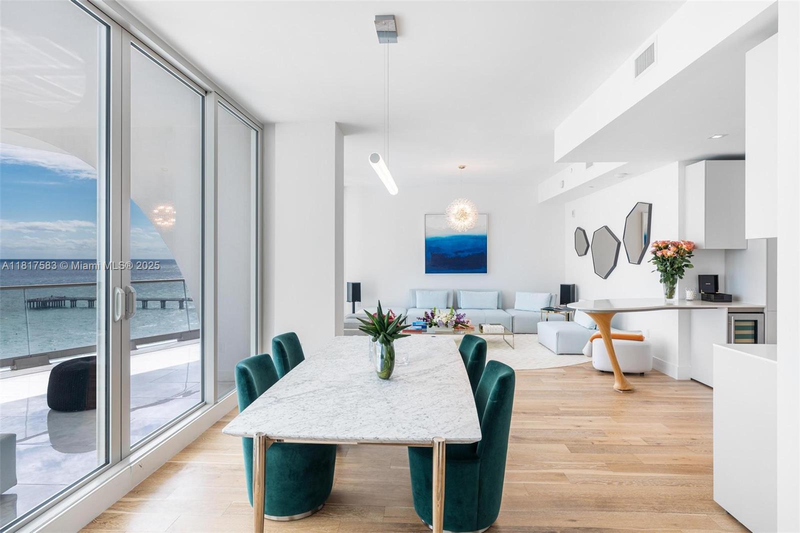 16901 Collins Avenue, Unit 902 Sunny Isles Beach, FL 33160 - Photo 6 of 52 a living room with chairs kitchen view and a wooden floor