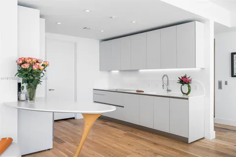 a kitchen with stainless steel appliances a sink cabinets and wooden floor