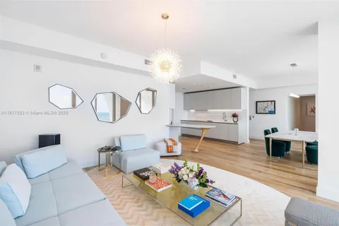 a living room with furniture kitchen view and a chandelier