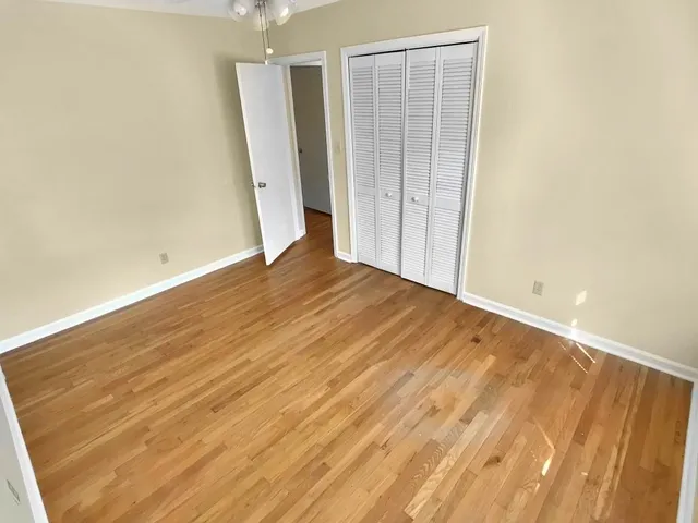an empty room with wooden floor and a bathroom
