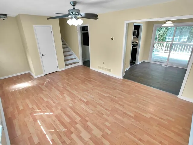 a view of a hallway with wooden floor and stairs
