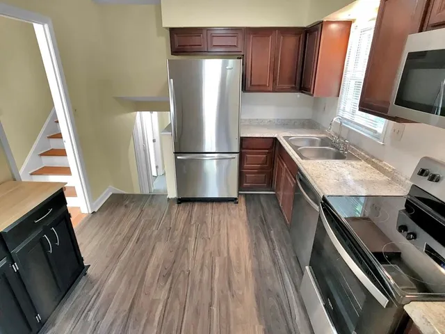 a kitchen with wooden floors and appliances