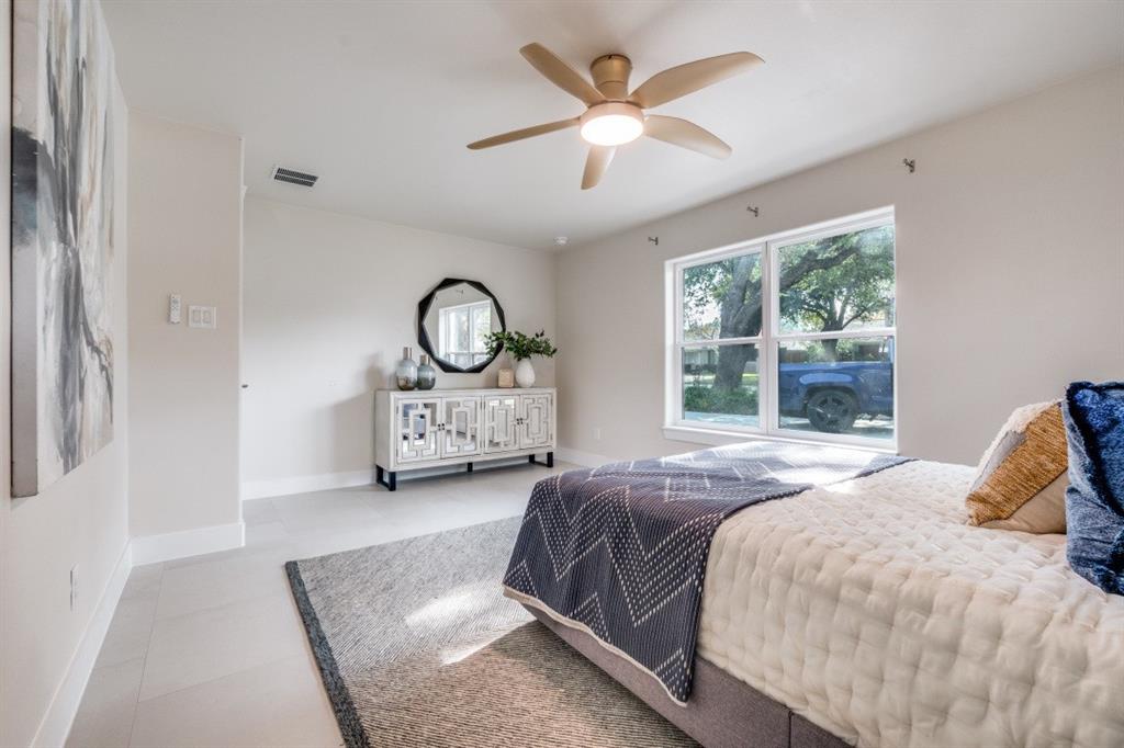 7115 Meadow Road Dallas, TX 75230 - Photo 15 of 22 This room features light-colored walls and flooring, a ceiling fan with integrated lighting, and a large window providing natural light