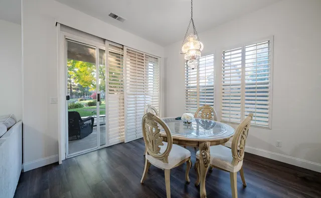 a view of a a dining room with furniture window and wooden floor