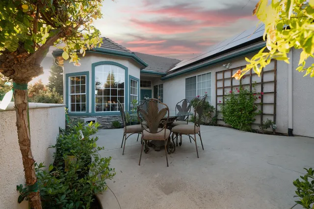 a view of a house with patio and a garden
