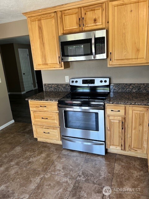 618 Cardinal Drive Walla Walla, WA 99362 - Photo 8 of 31 a kitchen with stainless steel appliances granite countertop a stove microwave and cabinets