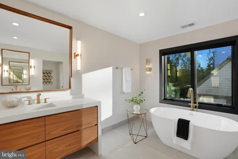 a bathroom with a tub sink and mirror