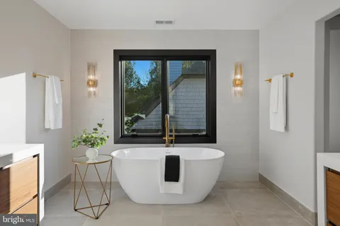 a white bath tub sitting in a bathroom next to a window