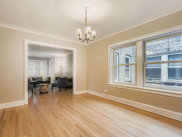 a view of a livingroom with furniture wooden floor chandelier and a window