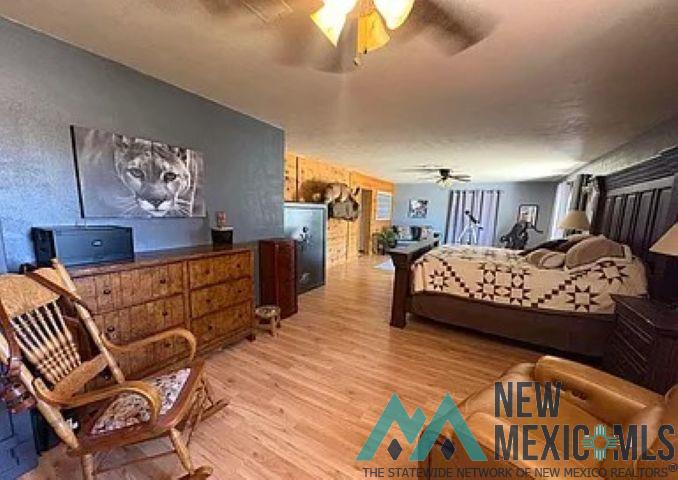 32 Hickey Road Pie Town, NM 87827 - Photo 15 of 39 Bedroom featuring light wood-style flooring and a ceiling fan