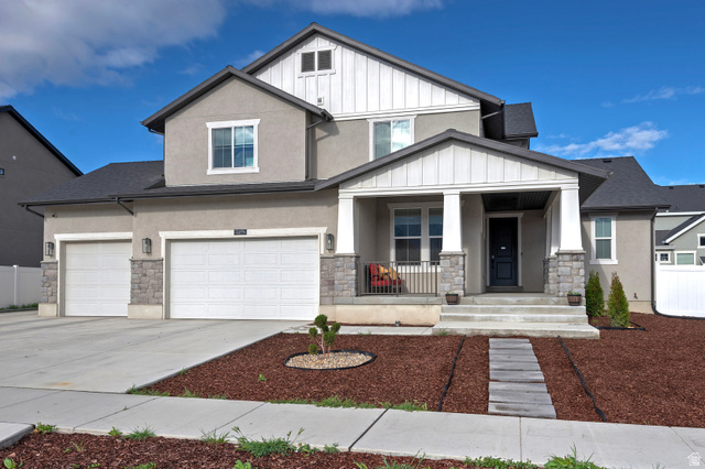 Craftsman-style home with covered porch, board and batten siding, concrete driveway, stone siding, and a garage