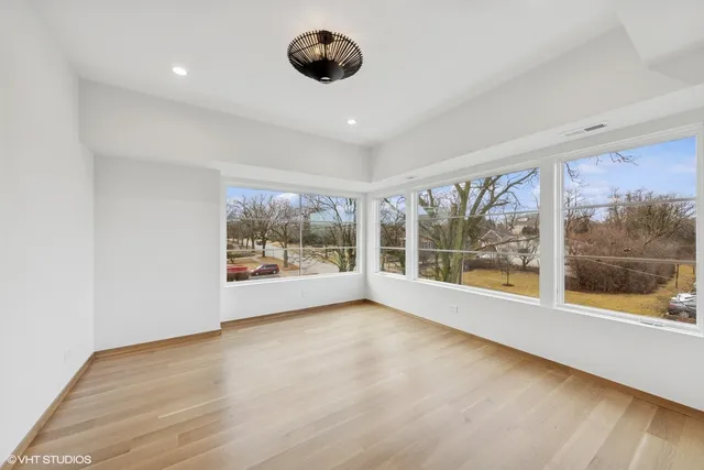 a view of an empty room with a window and a ceiling fan