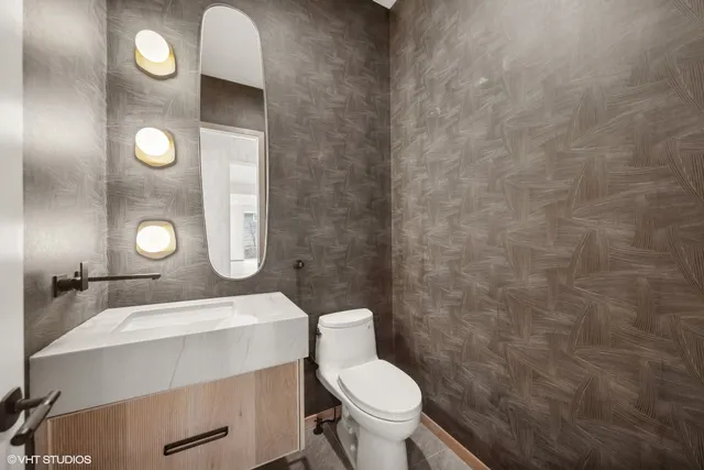 a bathroom with a toilet a sink and mirror