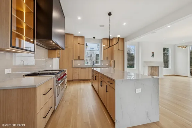 a kitchen with stainless steel appliances granite countertop a stove a sink a refrigerator and a wooden cabinets