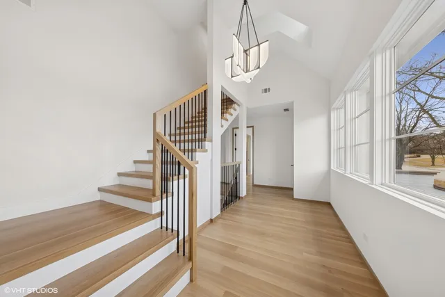 a view of a hallway with wooden floor and staircase
