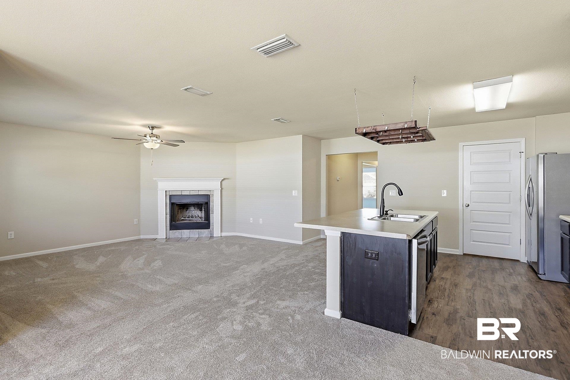 983 Summerton Drive Foley, AL 36535 - Photo 24 of 25 Kitchen featuring light countertops, stainless steel appliances, a kitchen island with sink, a tile fireplace, and open floor plan