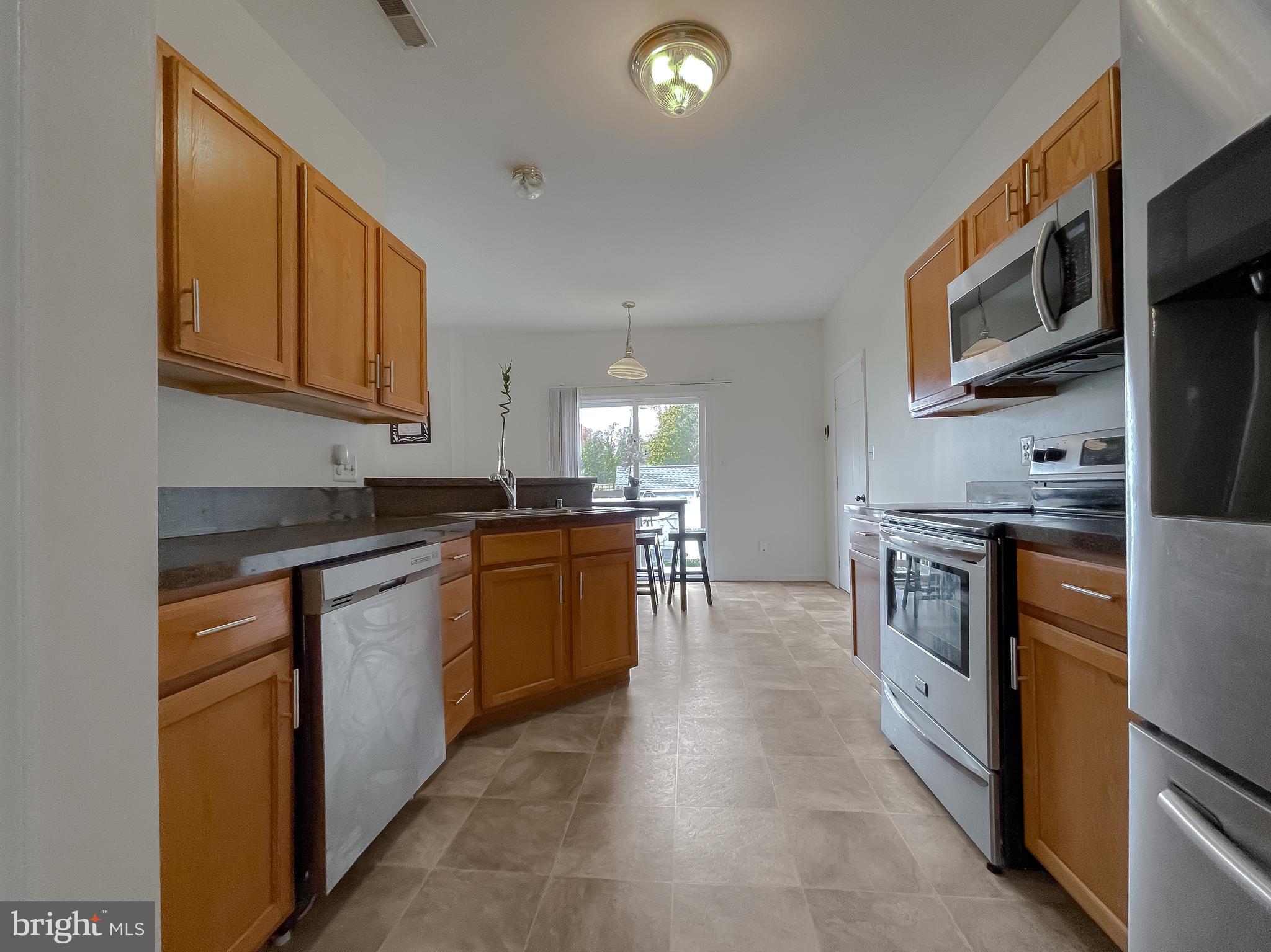 47162 Green Leaf Road Lexington Park, MD 20653 - Photo 20 of 50 a kitchen with stainless steel appliances granite countertop a stove a sink and a refrigerator