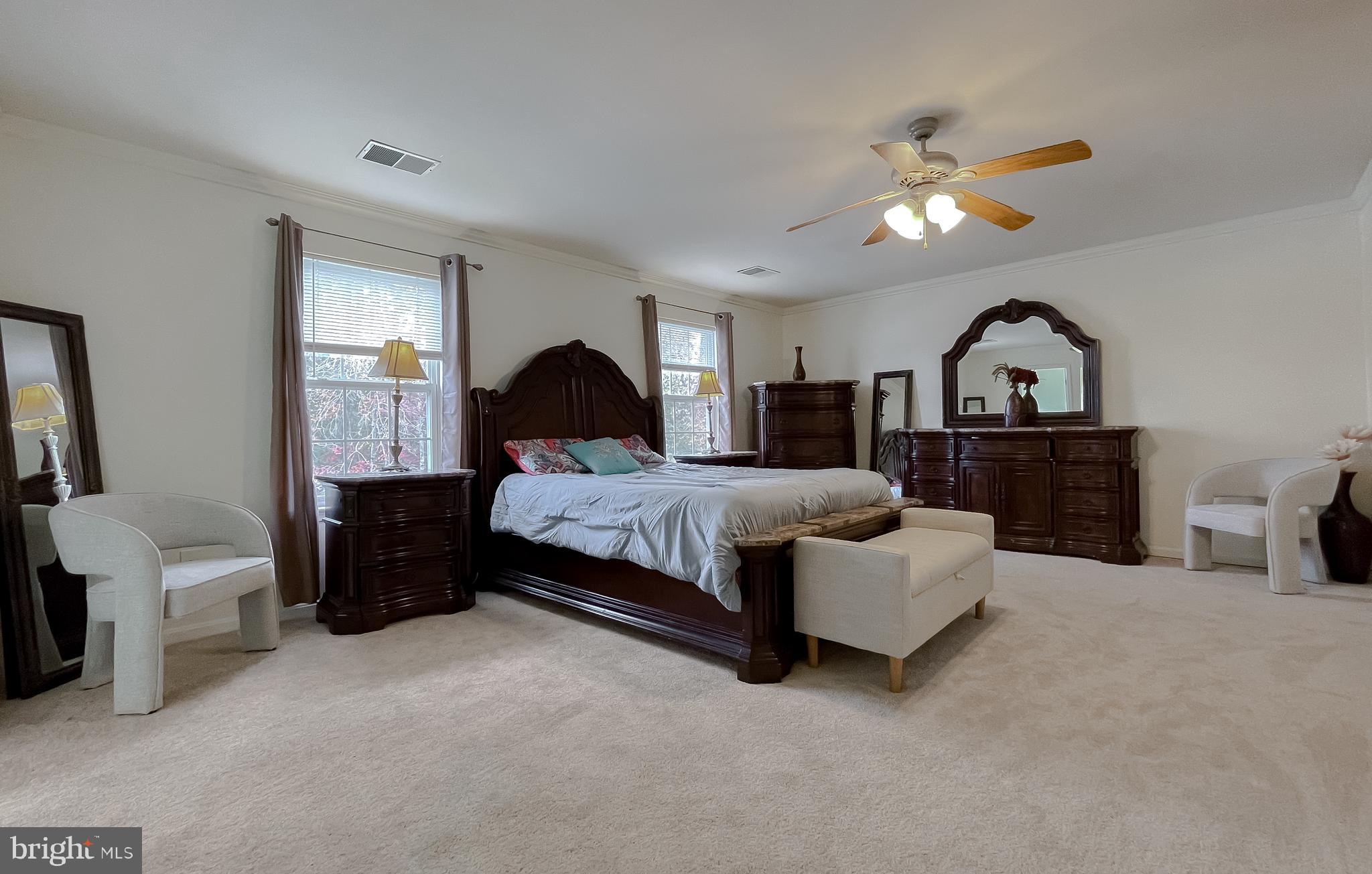 47162 Green Leaf Road Lexington Park, MD 20653 - Photo 25 of 50 a spacious bedroom with a bed and a chandelier