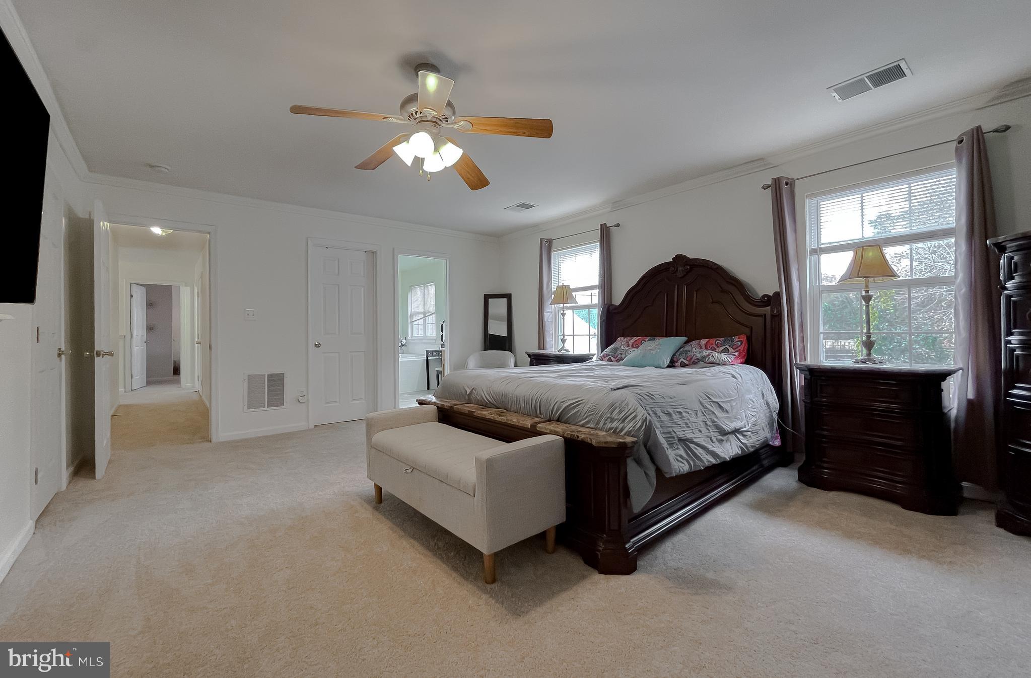 47162 Green Leaf Road Lexington Park, MD 20653 - Photo 26 of 50 a spacious bedroom with a bed and a chandelier