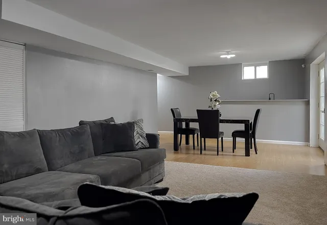 a living room with furniture and a dining table with kitchen view
