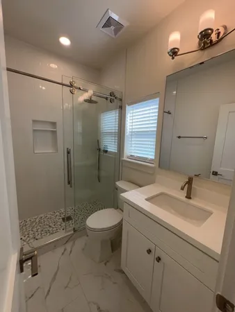 a bathroom with a sink toilet a mirror and shower