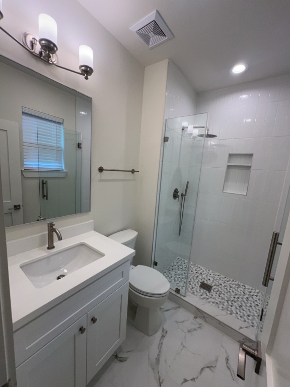 10607 Enclave Shadows Court Houston, TX 77043 - Photo 20 of 29 a bathroom with a sink a toilet and shower