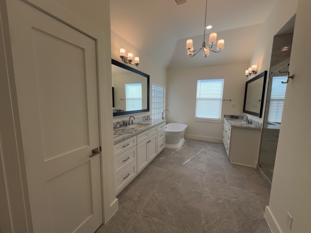 10607 Enclave Shadows Court Houston, TX 77043 - Photo 4 of 23 a bathroom with a double vanity sink a toilet a mirror and shower