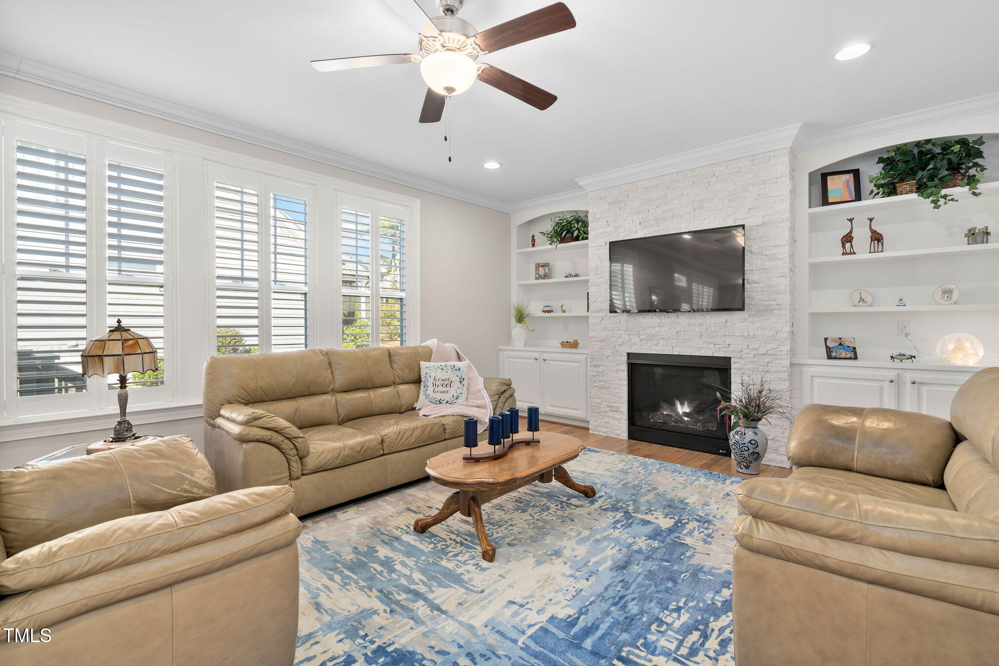 2461 Stonehenge Park Drive Raleigh, NC 27613 - Photo 15 of 72 a living room with furniture a flat screen tv and a fireplace