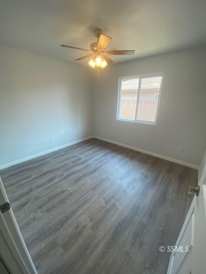 1009 West Boston Avenue Ridgecrest, CA 93555 - Photo 5 of 9 an empty room with wooden floor and windows