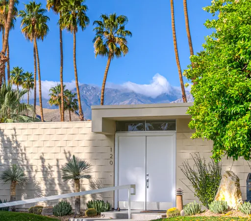 front view of a house with a palm tree