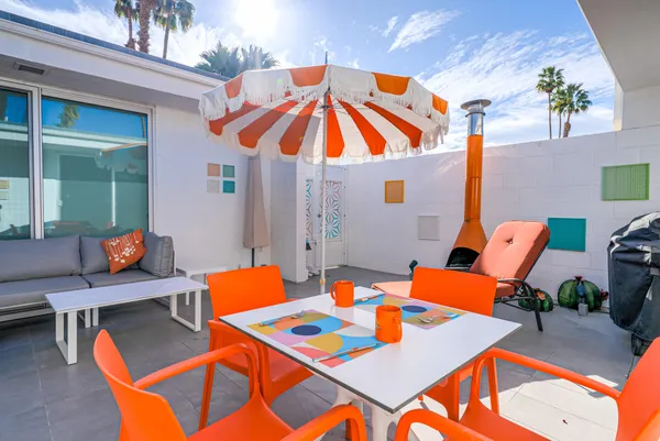 a view of a patio with a table and chairs under an umbrella
