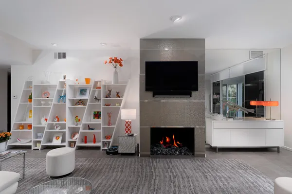 a living room with furniture a flat screen tv and a fireplace