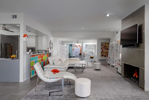 a living room with furniture a flat screen tv and a fireplace