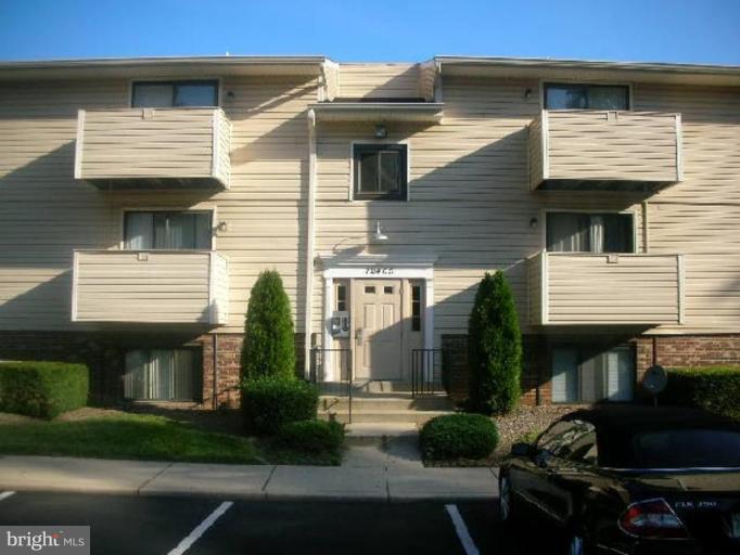 a view of a white house with potted plants