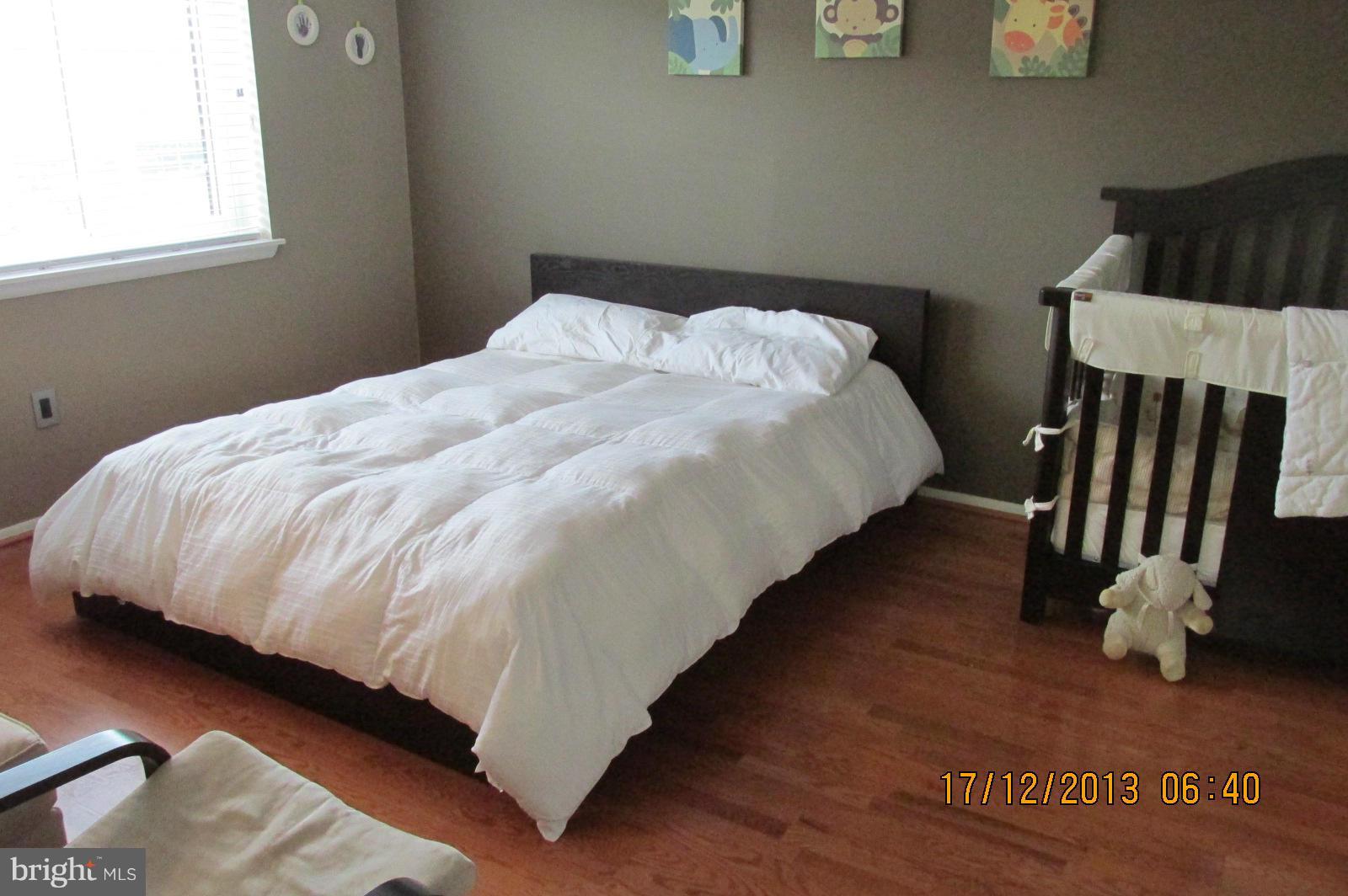 12405 Hickory Tree Way, Unit 613 Germantown, MD 20874 - Photo 6 of 9 a bed sitting in a bedroom next to a window