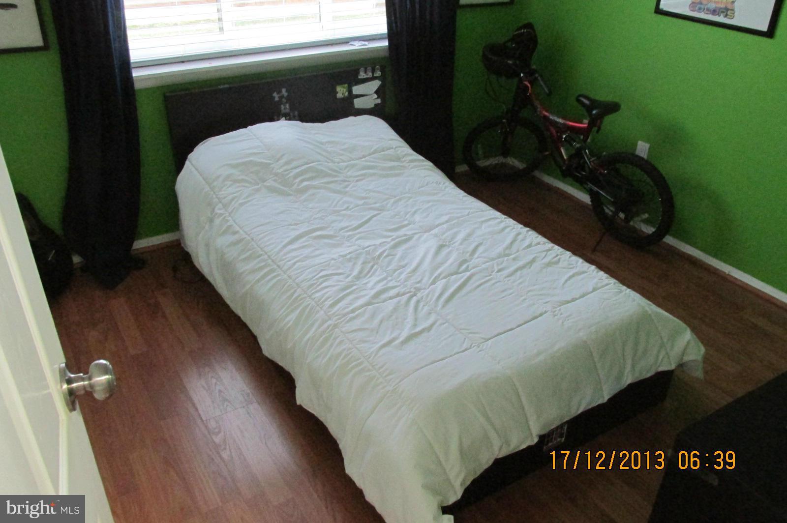 12405 Hickory Tree Way, Unit 613 Germantown, MD 20874 - Photo 7 of 9 a bed sitting in a bedroom next to a window