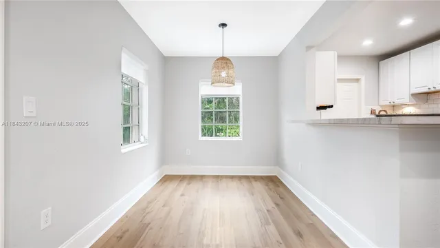 a view of a kitchen with wooden floor and windows