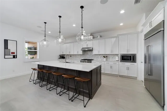 a kitchen with kitchen island granite countertop a sink cabinets and stainless steel appliances