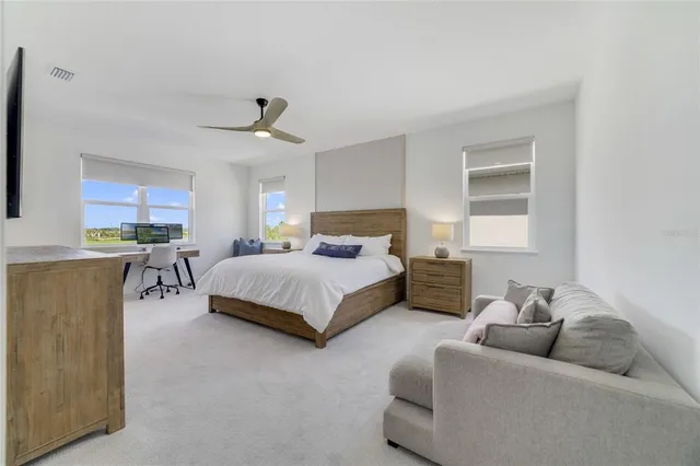 a spacious bedroom with a bed a couch and a flat screen tv