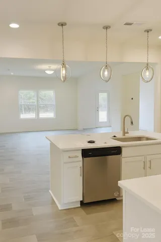 a kitchen with stainless steel appliances granite countertop a sink a stove and a wooden floor