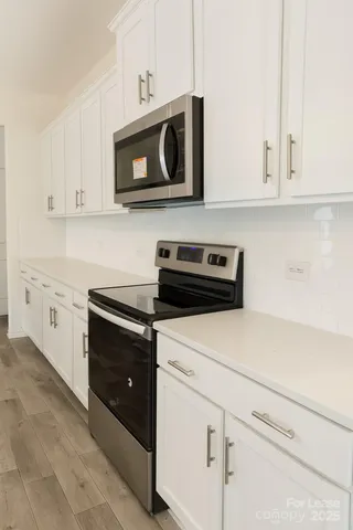 a kitchen with white cabinets and stainless steel appliances
