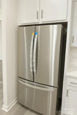 a close view of refrigerator and white kitchen with sink