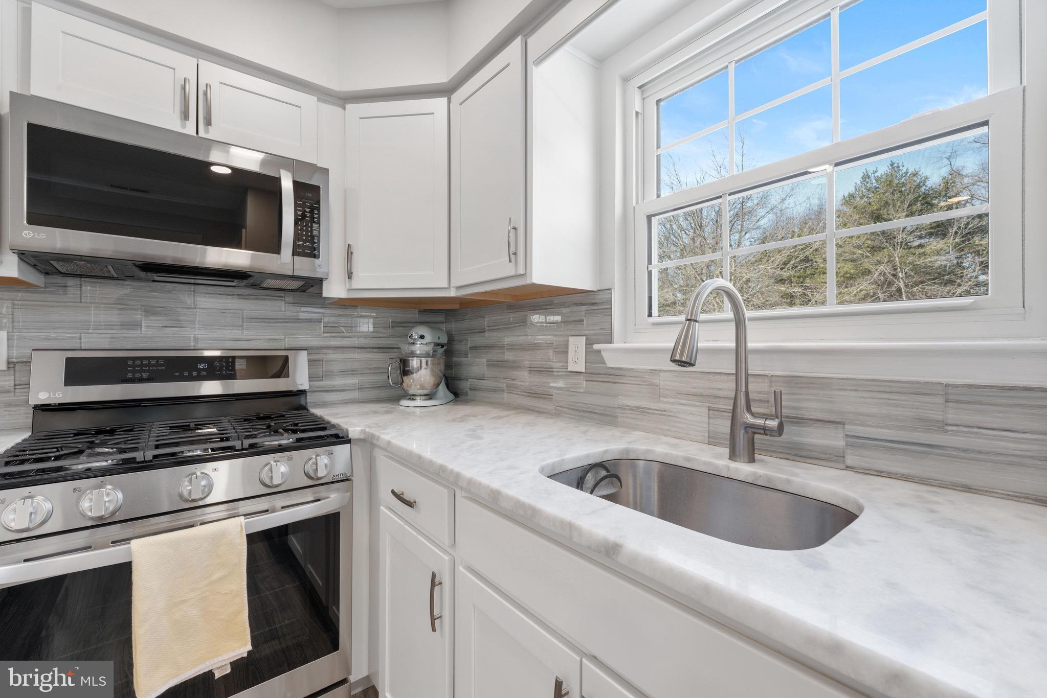 135 Buckingham Way Mount Laurel, NJ 08054 - Photo 16 of 30 a kitchen with stainless steel appliances a stove a microwave a sink and cabinets